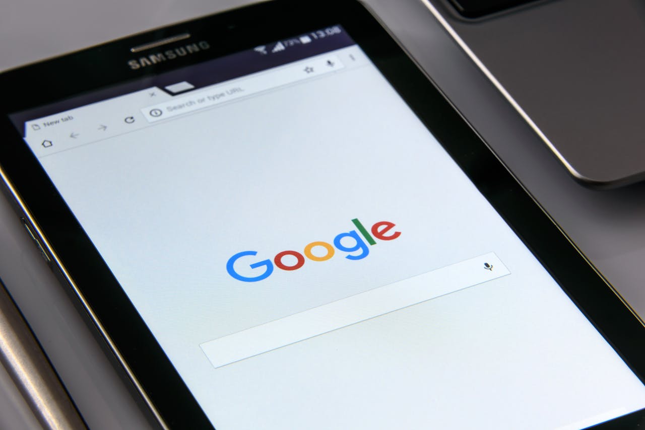 services-cta Close-up of a tablet displaying Googles search screen, emphasizing technology and internet browsing.